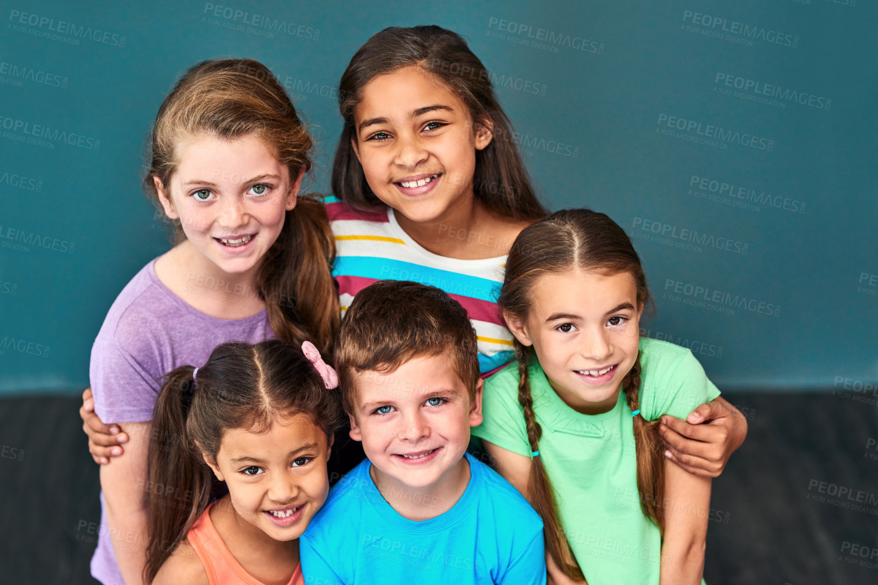 Buy stock photo Friends, happy and portrait of children hug on blue background for back to school, education and academy. Students, youth and group of kids smile for learning, scholarship and diversity in studio