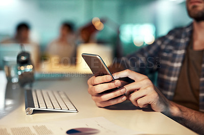 Buy stock photo Shot of an unrecognizable man using a smartphone at the office