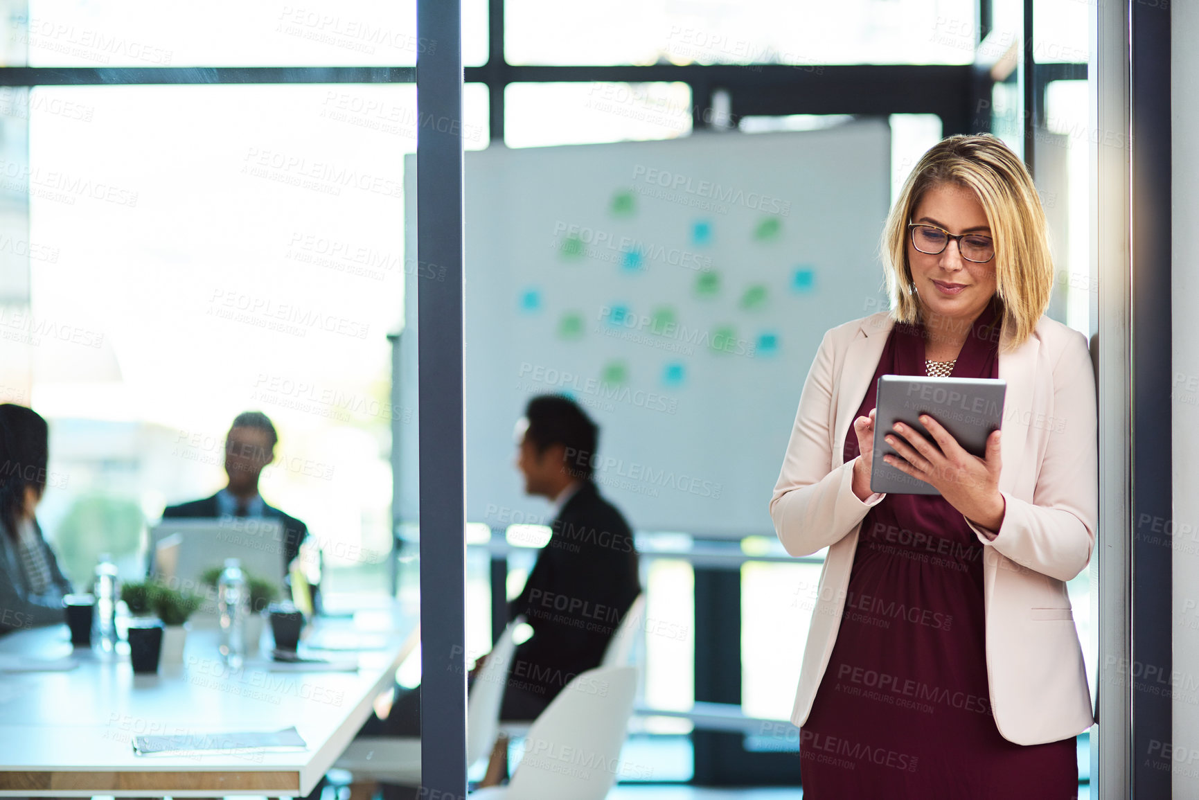 Buy stock photo Cropped shot of a beautiful young businesswoman using a tablet in the workplace