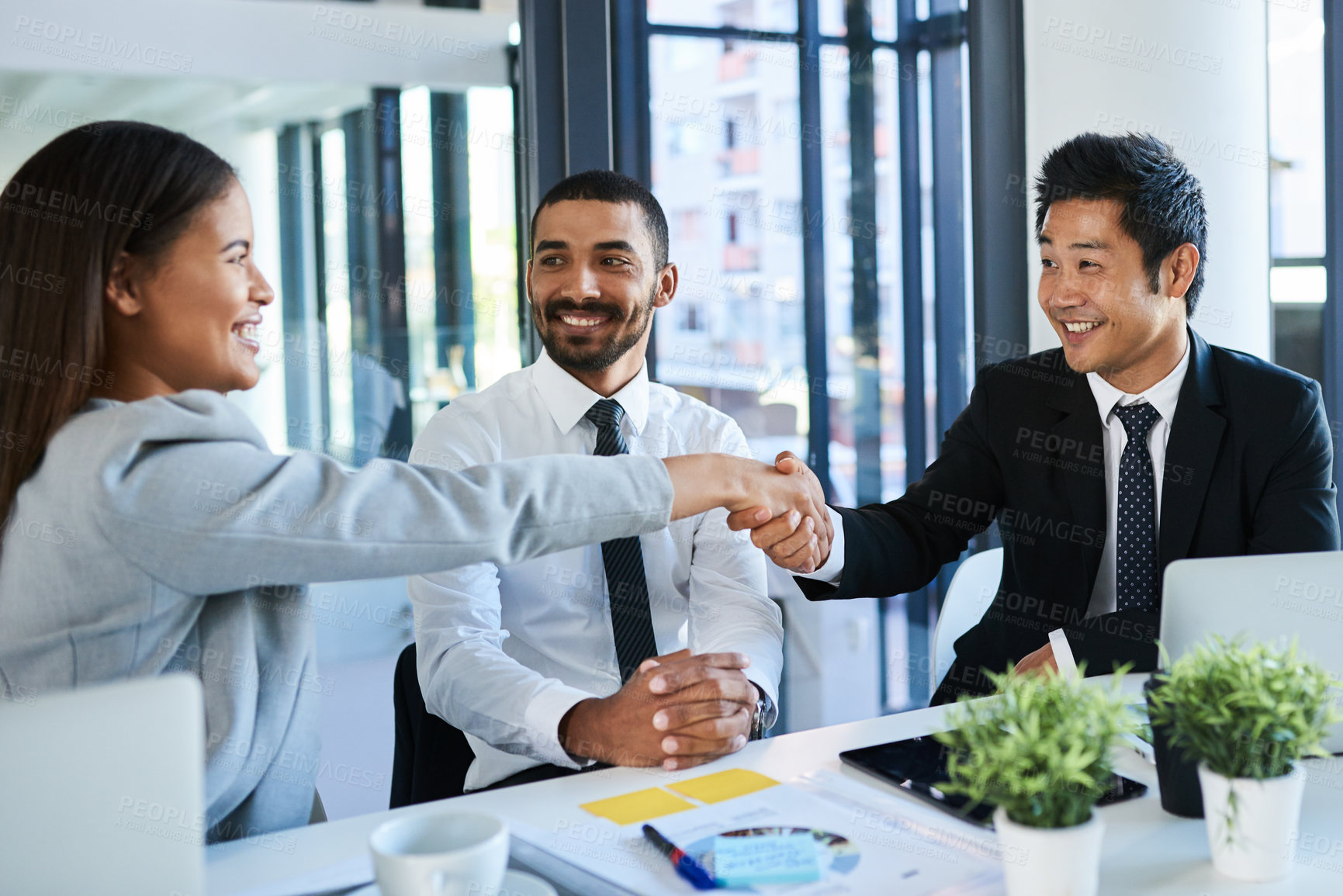 Buy stock photo Cropped shot of corporate businesspeople shaking hands in the workplace