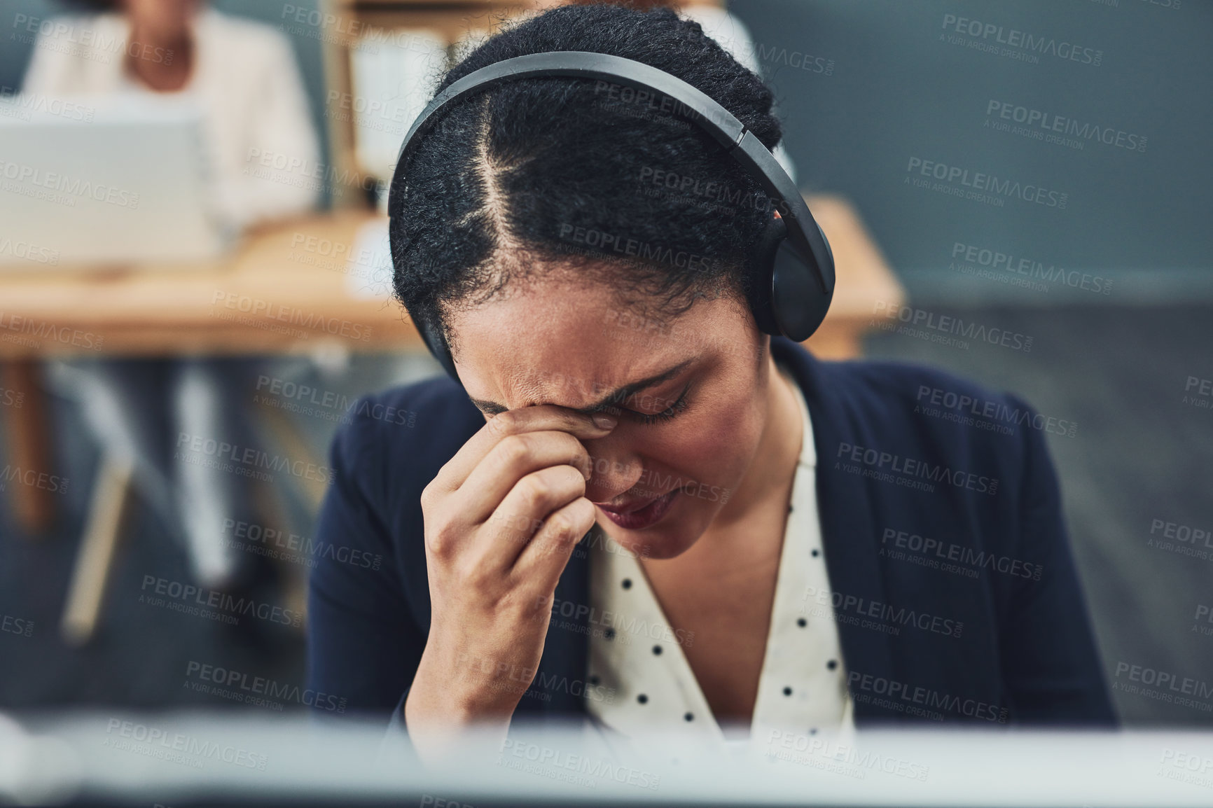 Buy stock photo Shot of a stressed out young businesswoman working on her computer while listening to a client over the phone inside the office at work