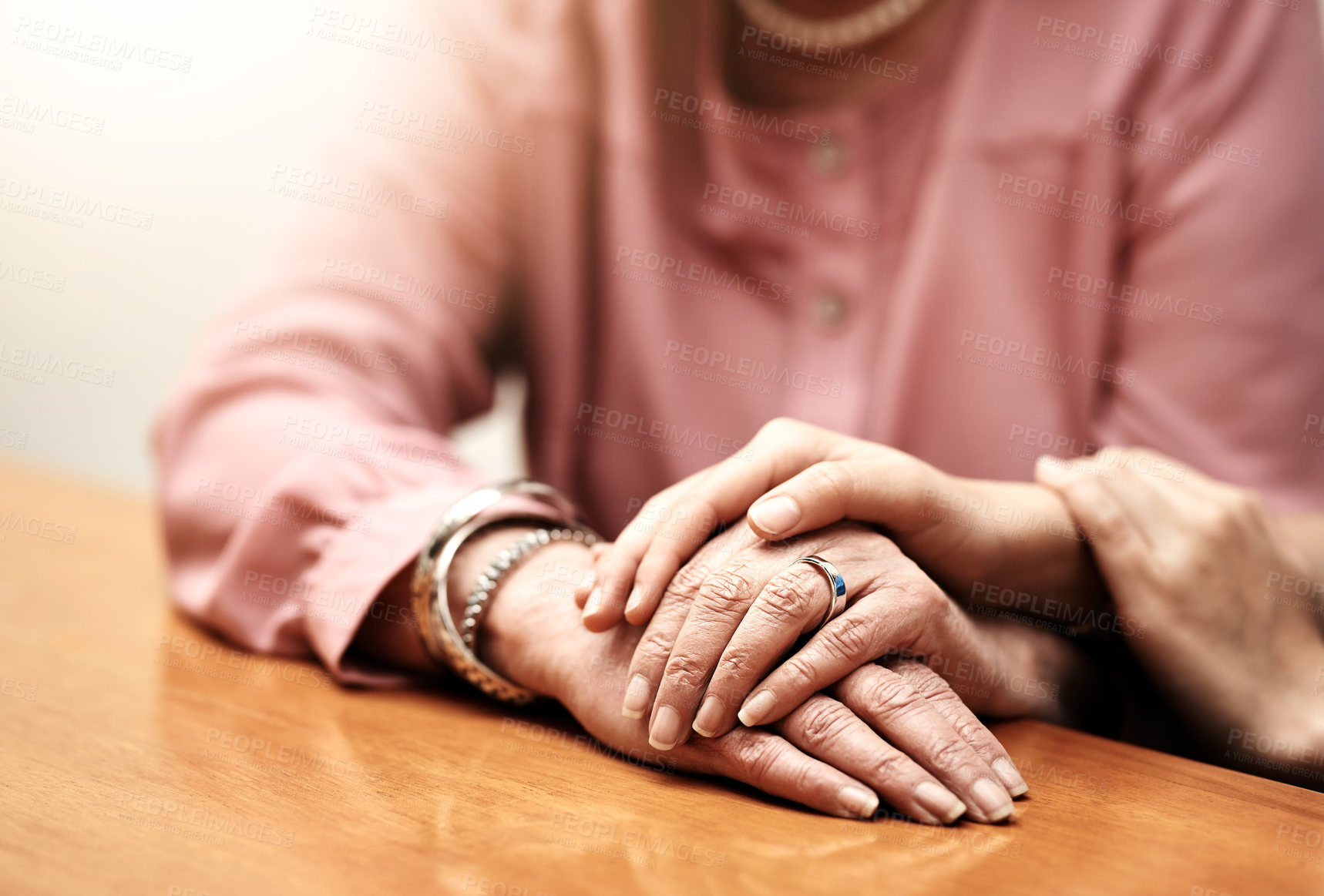 Buy stock photo Kindness, support and hands of people on table for compassion, empathy and comfort in hope together. Home, trust and women with gesture of love on desk for forgiveness, understanding and solidarity