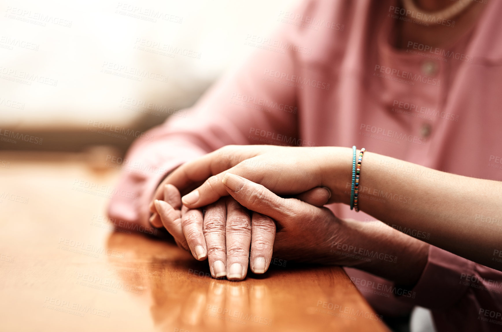 Buy stock photo Empathy, love and hands of people on table for support, compassion and solidarity in hope together. Home, trust and women with gesture of kindness on desk for comfort, forgiveness and understanding