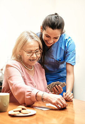 Buy stock photo Shot of a female nurse teaching her patient how to play a card game