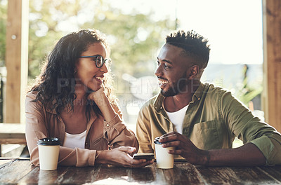 Buy stock photo Shot of a woman using her cellphone while sitting in a cafe with her boyfriend