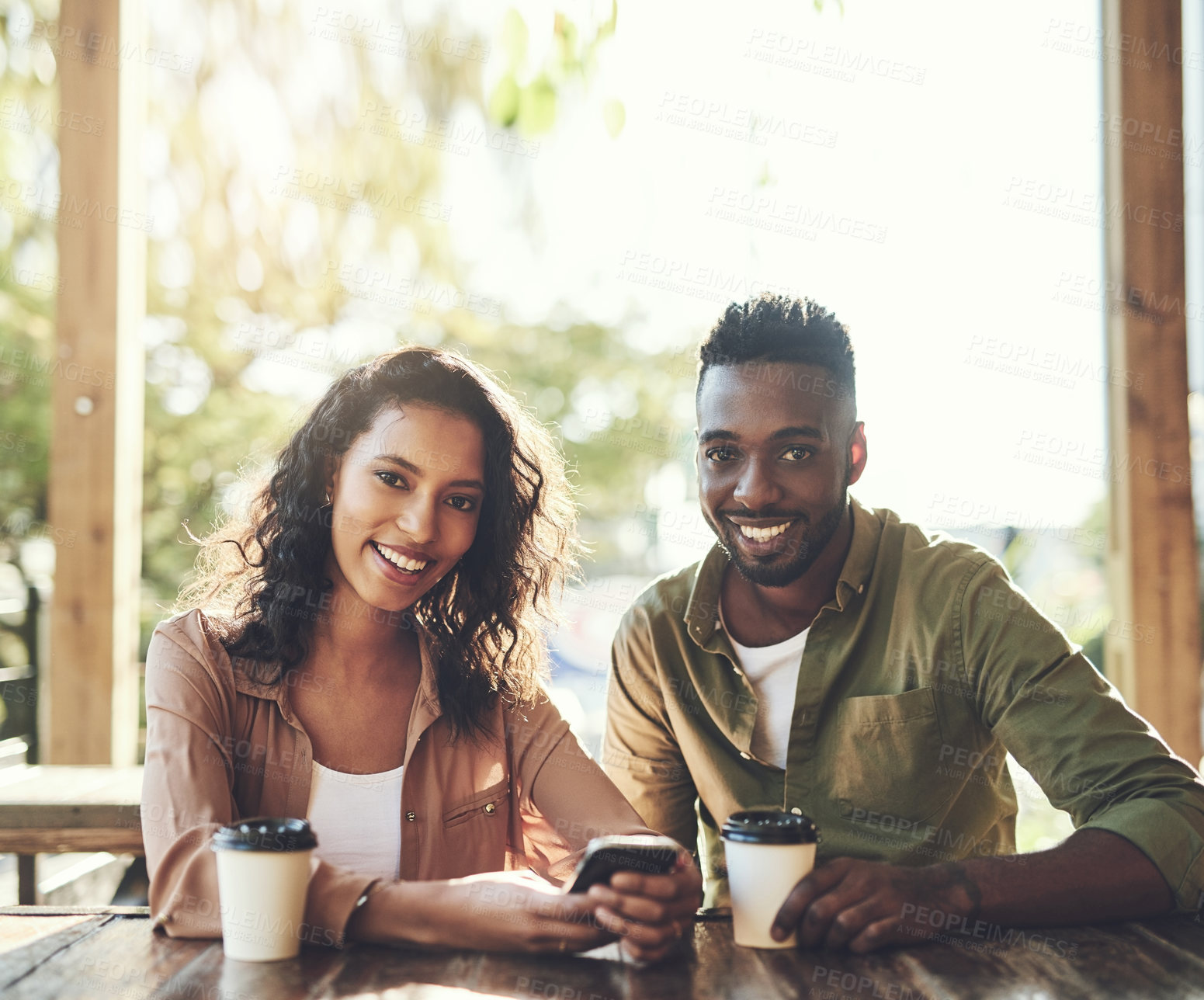 Buy stock photo African couple, smile and restaurant with phone for communication and conversation with drink. Woman, man and interracial relationship with smartphone on coffee shop date with happy bonding portrait