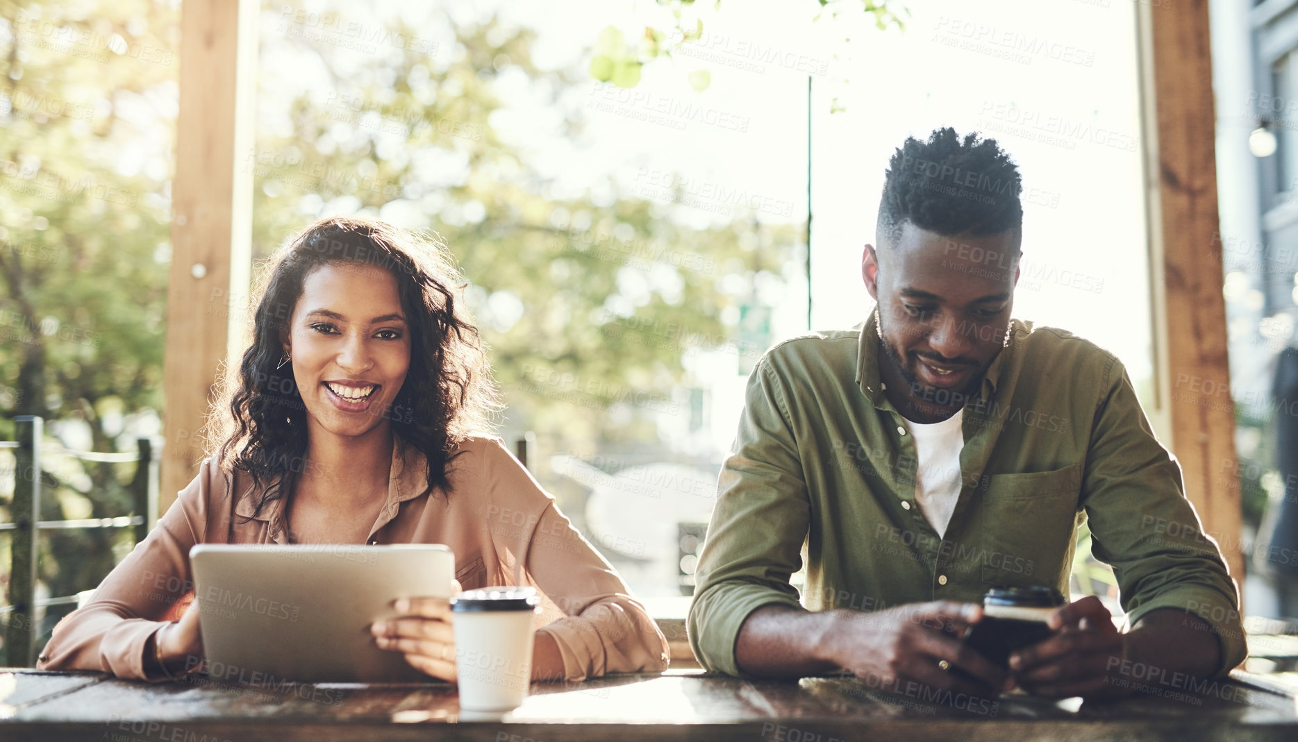 Buy stock photo Interracial, couple and online with coffee at cafe for morning breakfast, social media and communication. People, smile and tablet or cellphone for browsing website, reading email and restaurant date