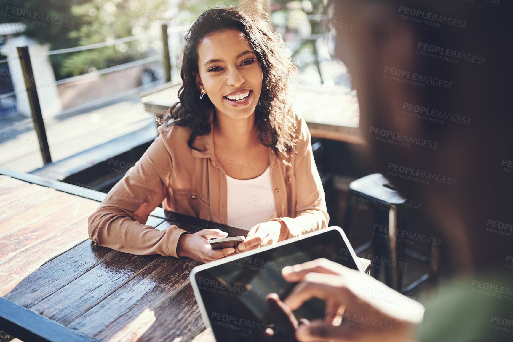 Buy stock photo Shot of a young woman placing her order with a waiter using a digital tablet