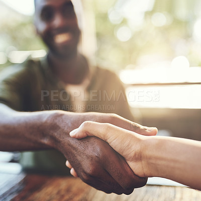 Buy stock photo Cropped shot of two people shaking hands in a cafe