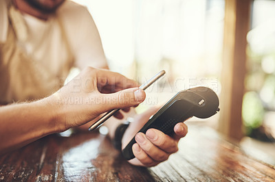 Buy stock photo Cropped shot of a customer making a wireless payment in a coffee shop