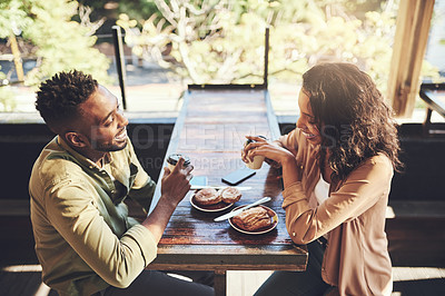 Buy stock photo Shot of a young couple having pastries at a coffee shop