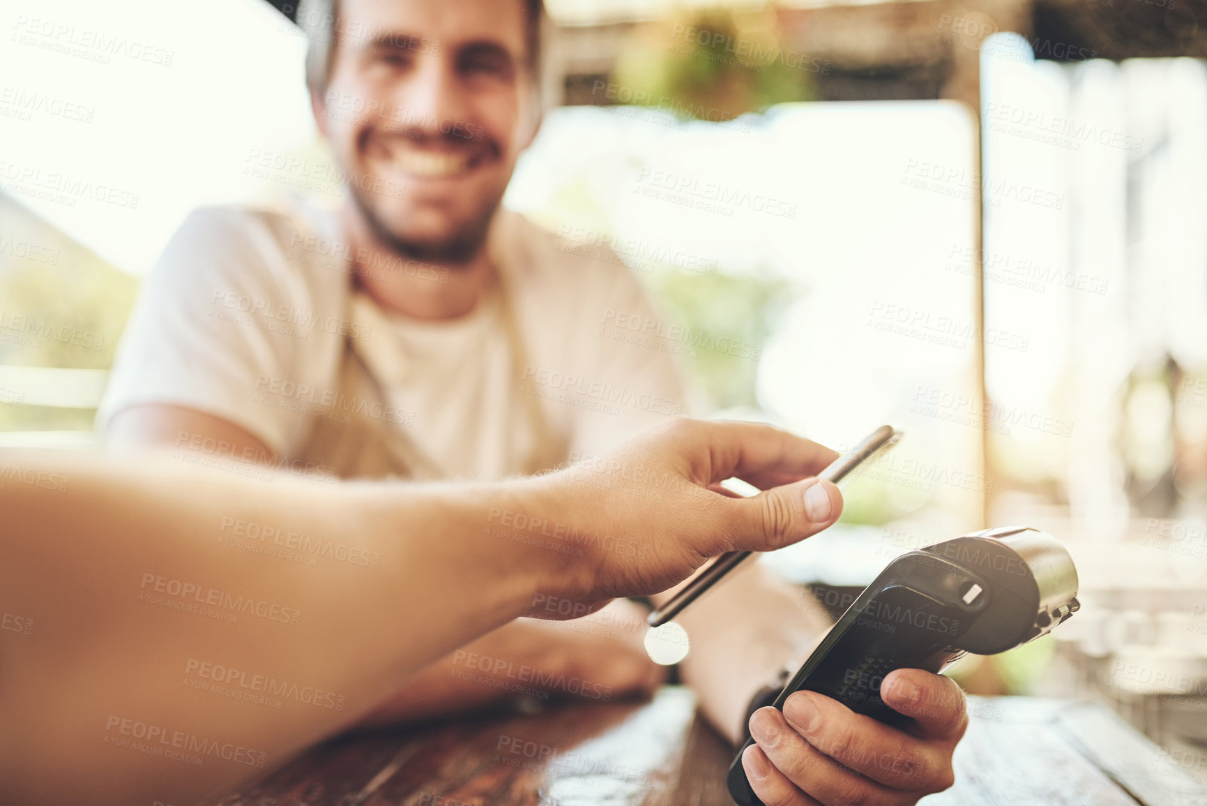 Buy stock photo Cropped shot of a customer making a wireless payment in a coffee shop