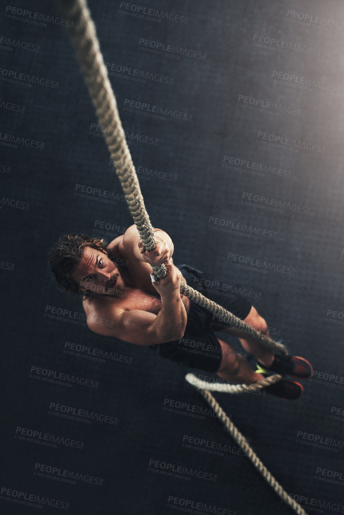 Buy stock photo Above, climbing and man with rope, fitness and endurance with challenge, wellness and workout. Person, athlete and bodybuilder with practice for sports, training and healthy with cardio in gym