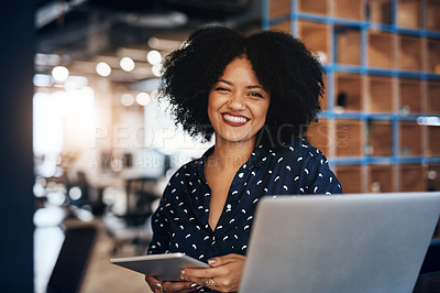 Buy stock photo Portrait of a young focussed female designer working on her laptop and digital tablet at the office during the day