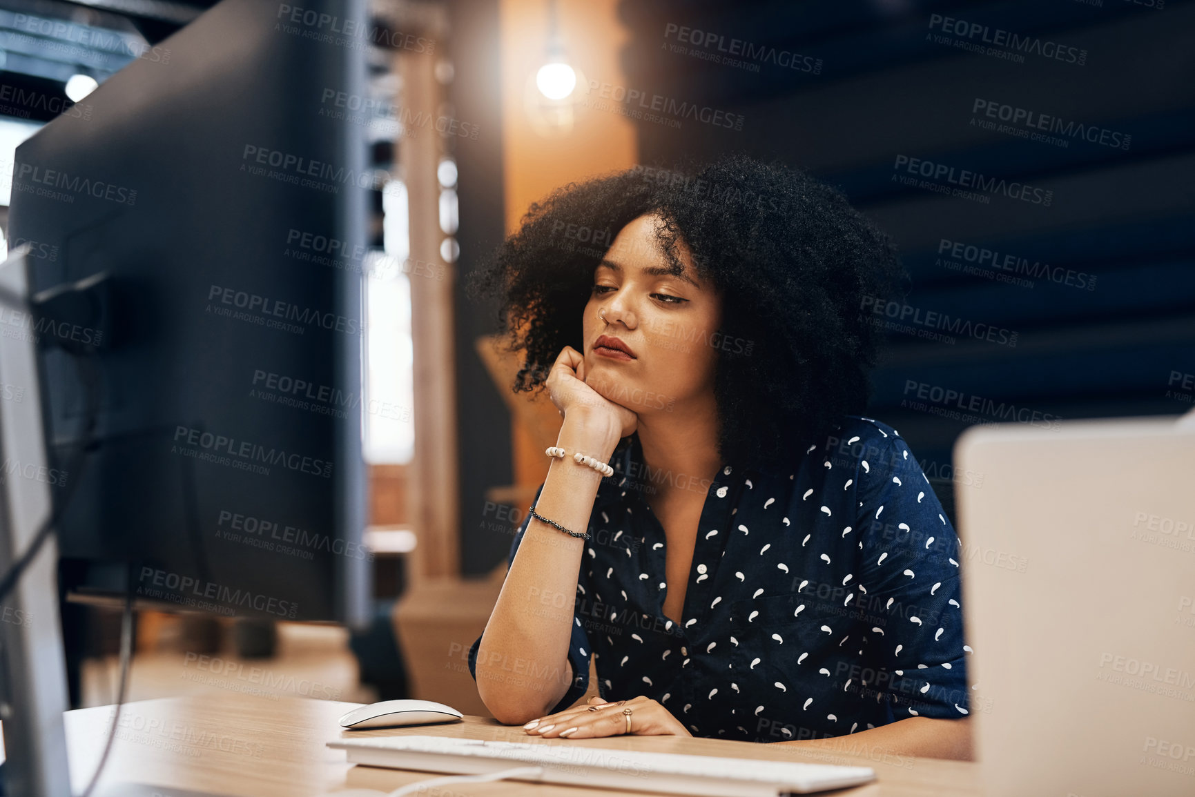 Buy stock photo Shot of a young tired looking female designer falling asleep behind her computer at the office during the day