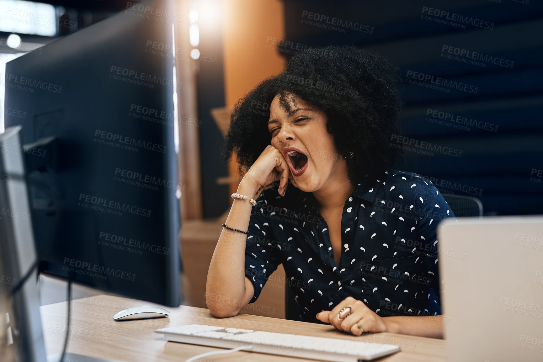 Buy stock photo Shot of a young tired looking female designer falling asleep behind her computer at the office during the day