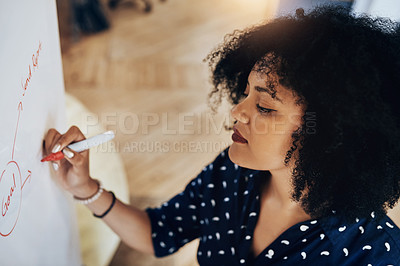 Buy stock photo High angle shot of a young female designer doing some planning on a white board in the office