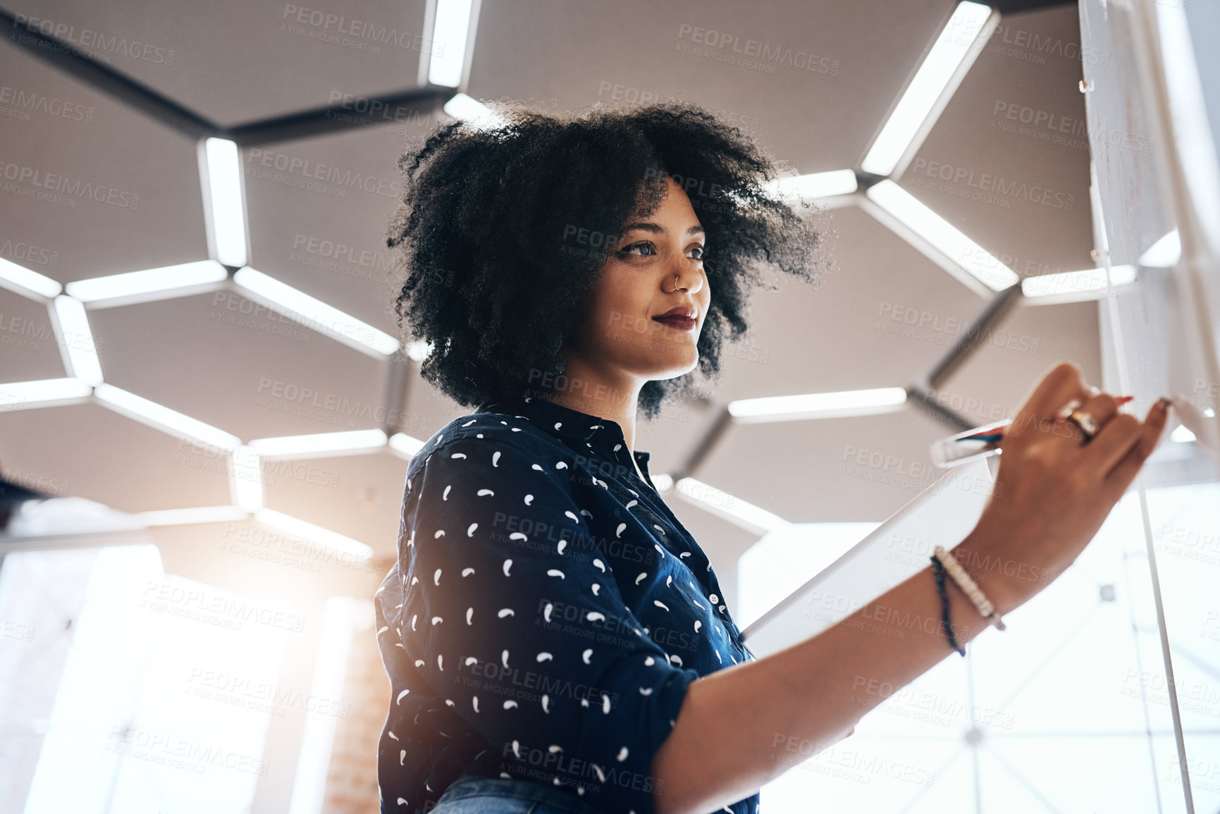 Buy stock photo Shot of a young female designer doing some planning on a white board in the office