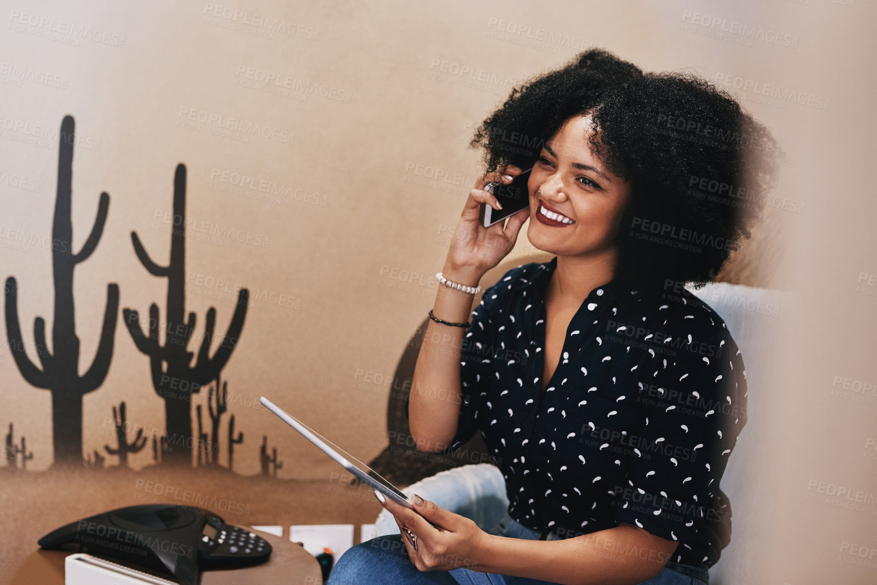 Buy stock photo Shot of a young female designer making a phone call while holding a digital tablet at her office desk