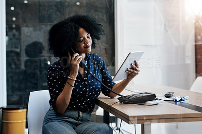 Buy stock photo Shot of a young female designer making a phone call while holding a digital tablet at her office desk