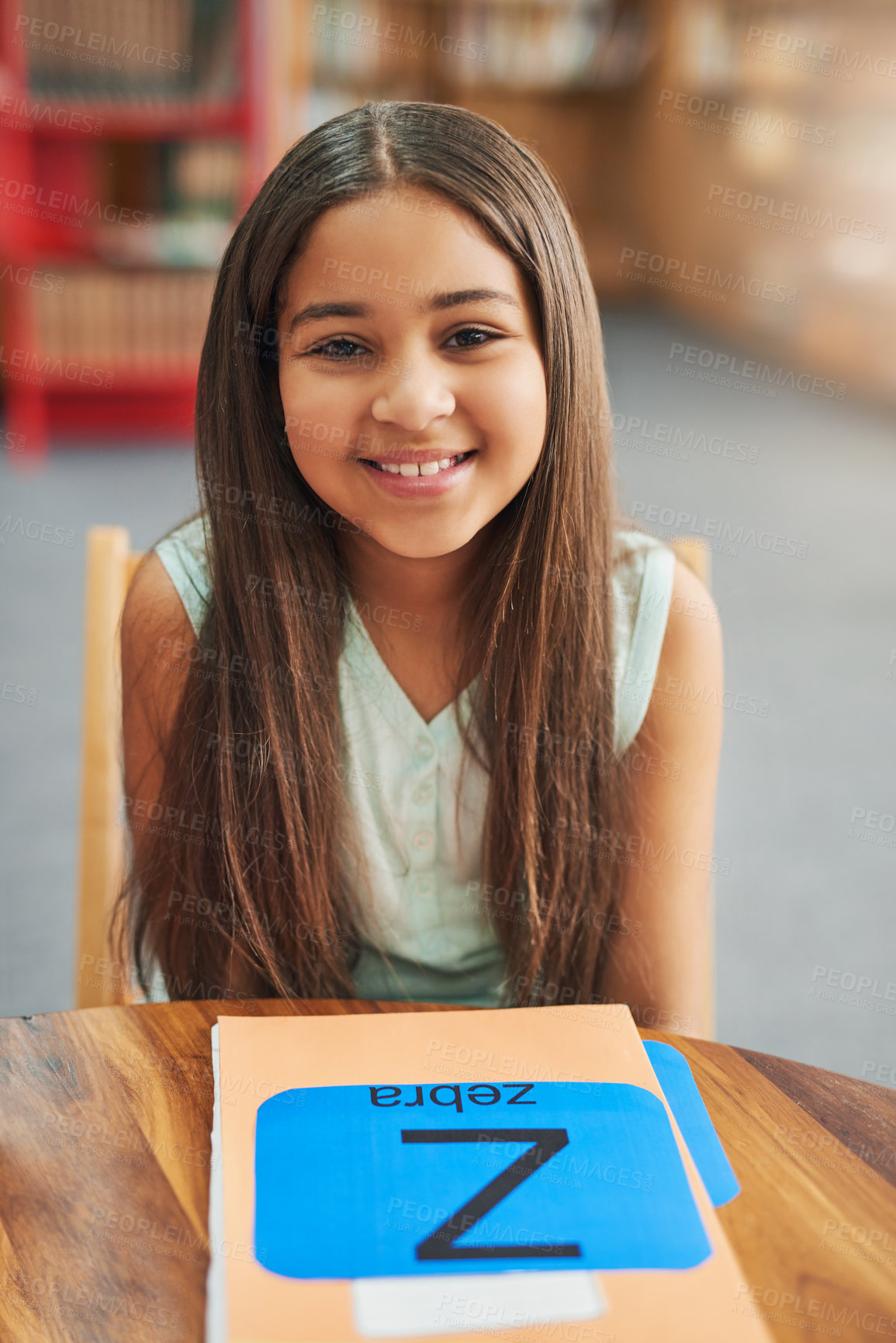 Buy stock photo Girl, child and portrait in library with books, happy and alphabet for education, development and progress. Kid, smile and folder for notes, language and scholarship for studying at school in Mexico