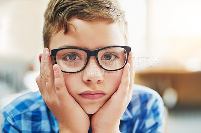 Buy stock photo Portrait of a young boy looking stressed while being seated inside of a classroom during the day