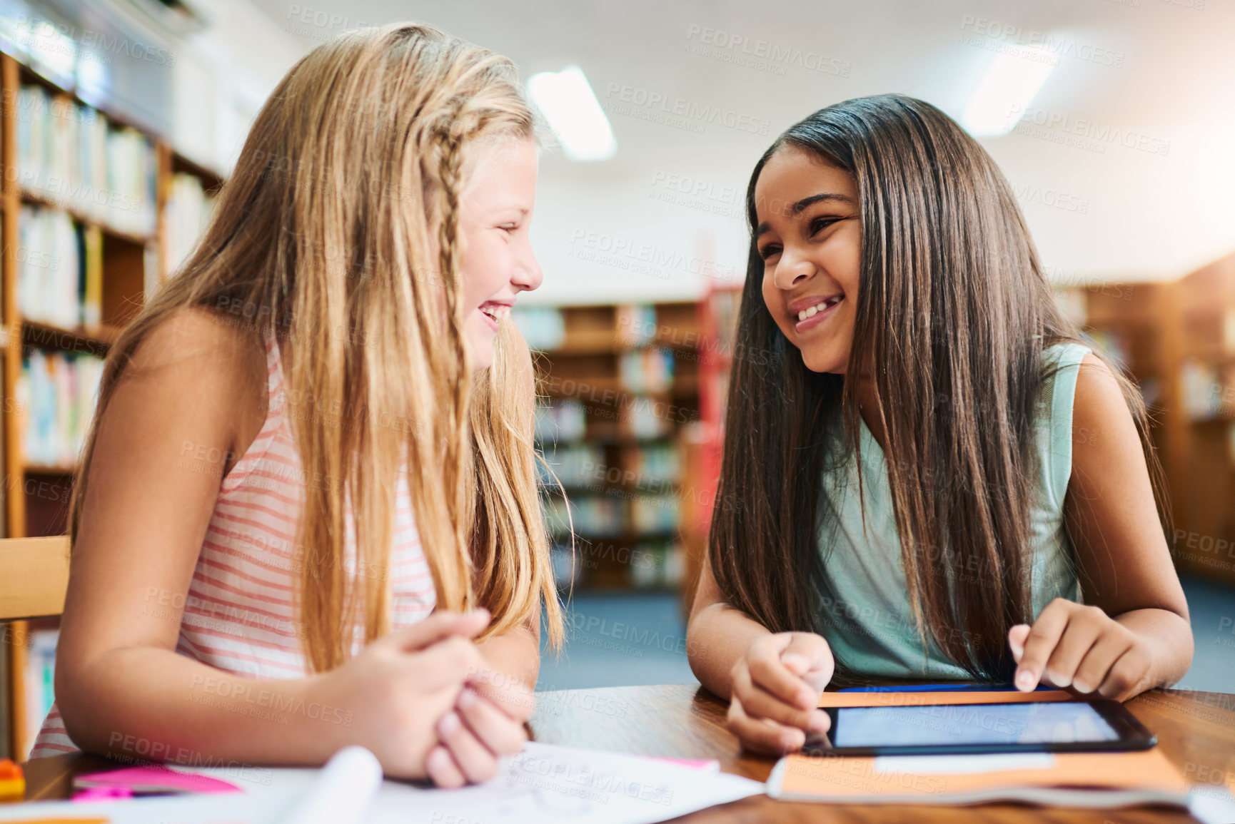 Buy stock photo Tablet, child and friends in library for learning, education or reading info for knowledge. Happy students, girl and smile on tech at school for studying, teamwork or watch online course together