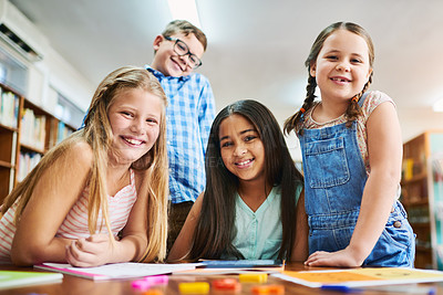 Buy stock photo Portrait of a group of cheerful young school children working together inside of a classroom during the day