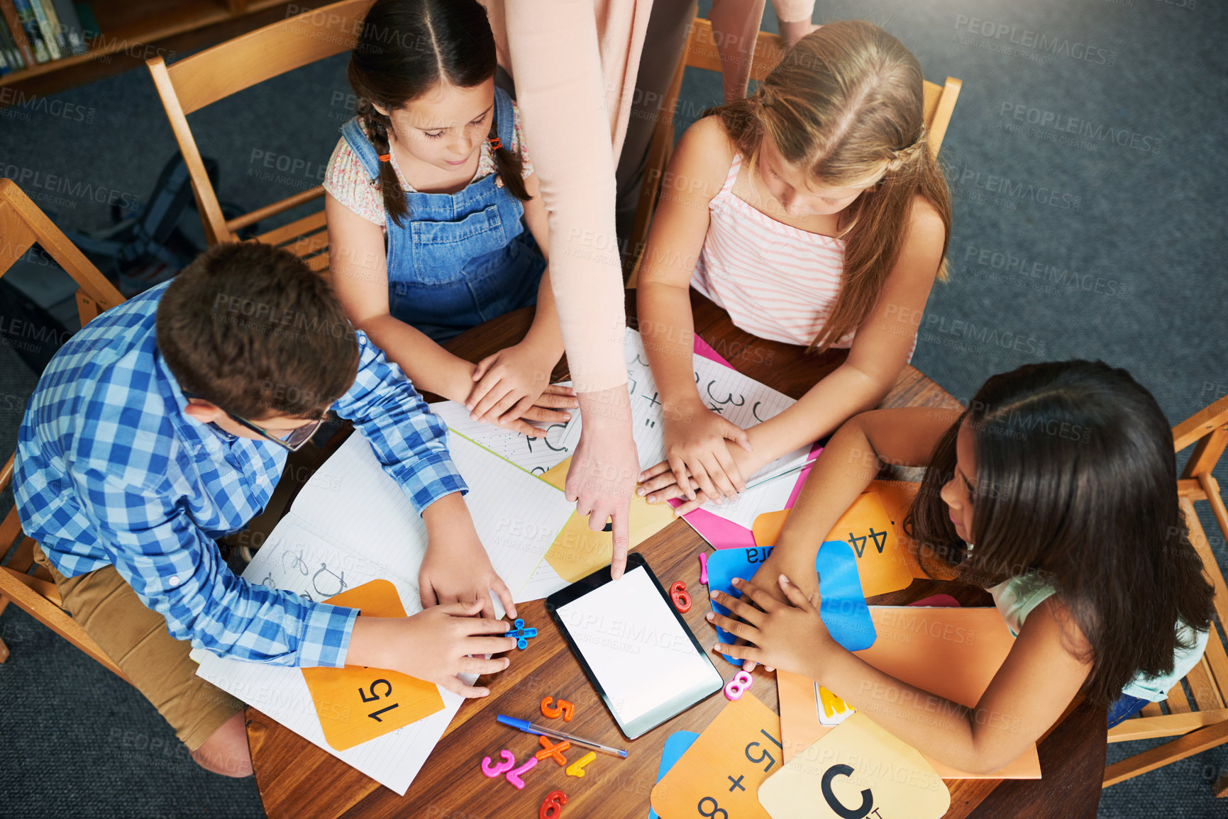 Buy stock photo Children, teacher and tablet for education with help, mockup space and blank screen in classroom. People, above and group learning with books, math and point at touchscreen for development at school