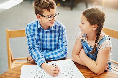 Buy stock photo Shot of two young children working together inside of a classroom during the day