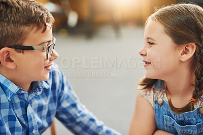 Buy stock photo Shot of two young children working together inside of a classroom during the day