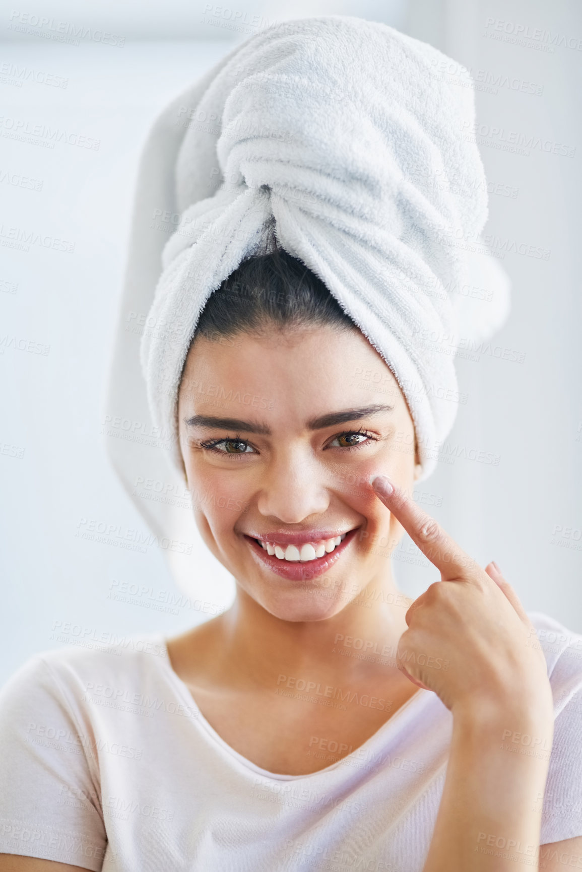 Buy stock photo Portrait of a beautiful young woman applying moisturizer to her skin in the bathroom at home