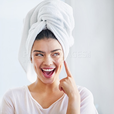 Buy stock photo Shot of a beautiful young woman applying moisturizer to her skin in the bathroom at home