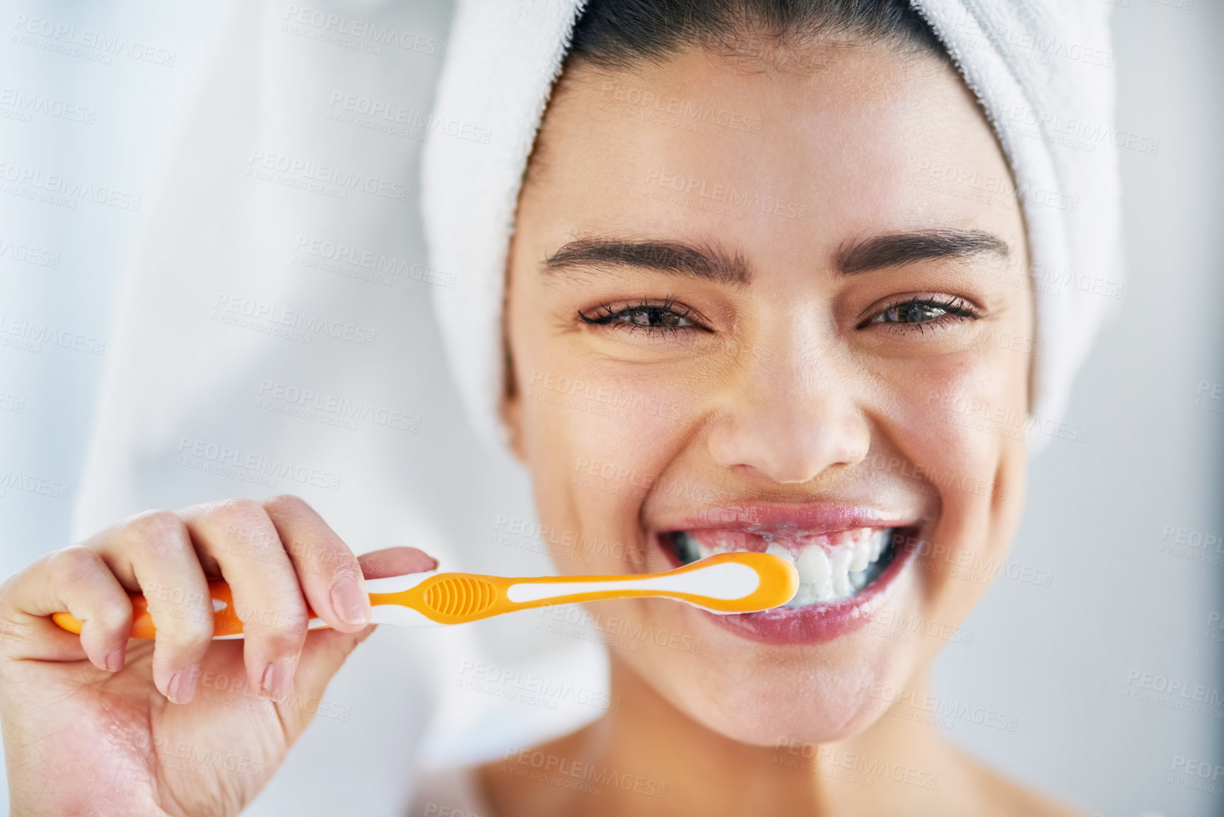 Buy stock photo Portrait of a beautiful young woman brushing her teeth in the bathroom at home