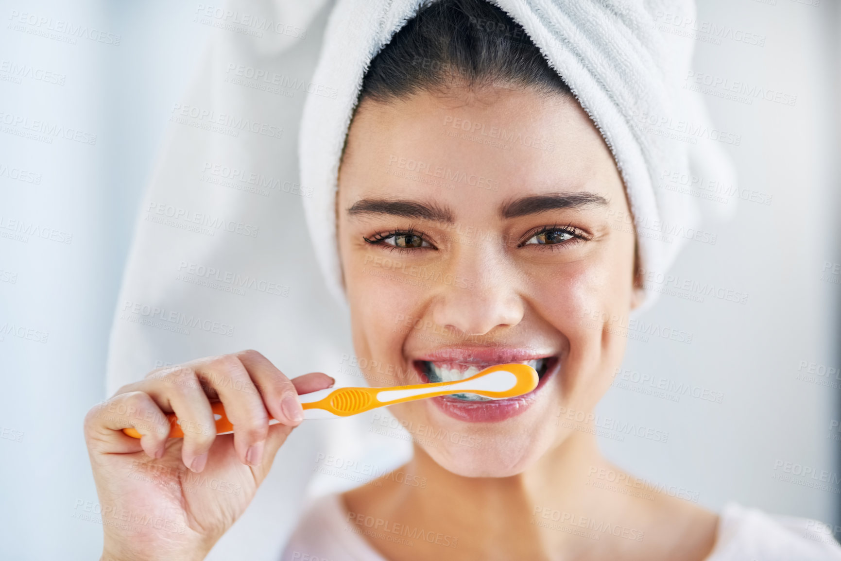 Buy stock photo Portrait of a beautiful young woman brushing her teeth in the bathroom at home