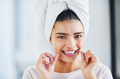 Buy stock photo Portrait of a beautiful young woman flossing her teeth in the bathroom at home
