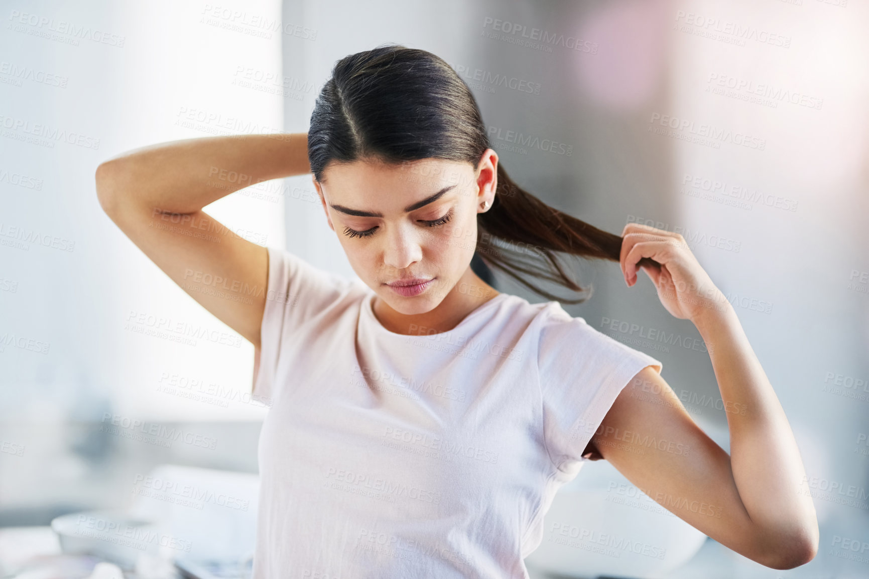 Buy stock photo Shot of a beautiful young woman styling her hair in the bathroom at home