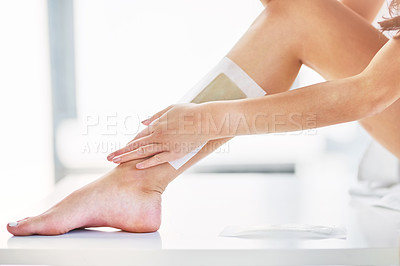 Buy stock photo Closeup shot of an unrecognizable woman waxing her legs in the bathroom at home