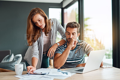 Buy stock photo Shot of an affectionate young couple working on their household budget