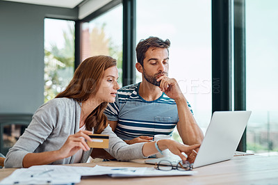 Buy stock photo Shot of a young couple working on their household budget and paying bills online