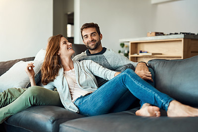 Buy stock photo Full length shot of an affectionate young couple relaxing on their sofa at home