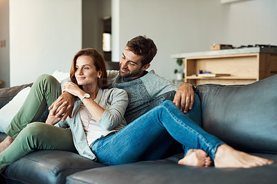 Buy stock photo Full length shot of an affectionate young couple relaxing on their sofa at home