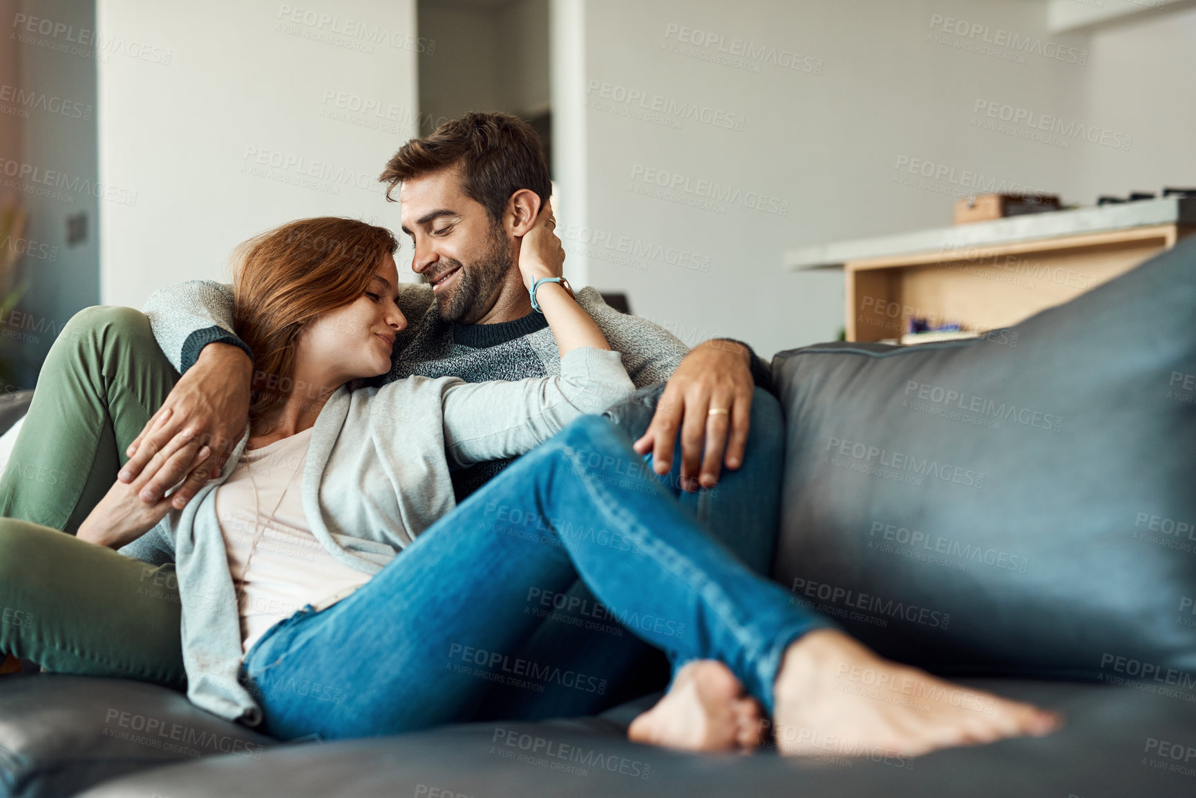 Buy stock photo Couple, smile and relax on sofa in house for comfort, love and bonding time together with trust and care. Man, woman and holding hands in living room for connection, peace and support on weekend 