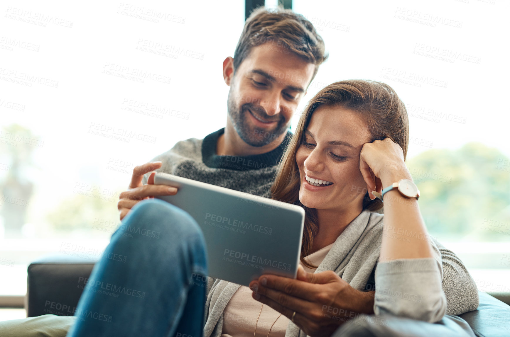 Buy stock photo Excited, couple and tablet on sofa for streaming , movie selection or tv choice with communication at home. Smile, man and woman with technology and show options on couch for bonding and discussion