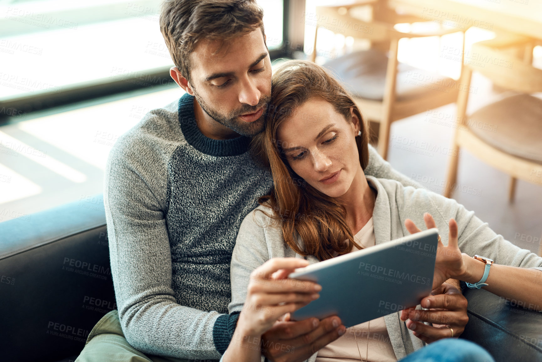 Buy stock photo Search, man and woman with tablet on sofa for streaming, movie selection or tv choice at home. Calm, couple and discussion with technology and love embrace on couch for bonding and scrolling web app