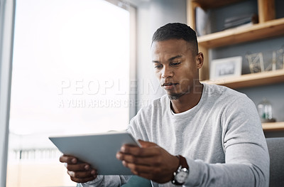 Buy stock photo Internet, tablet and man on couch reading social media post, email or streaming video on subscription service. Scroll, search and person with serious face and checking online movie website on sofa.