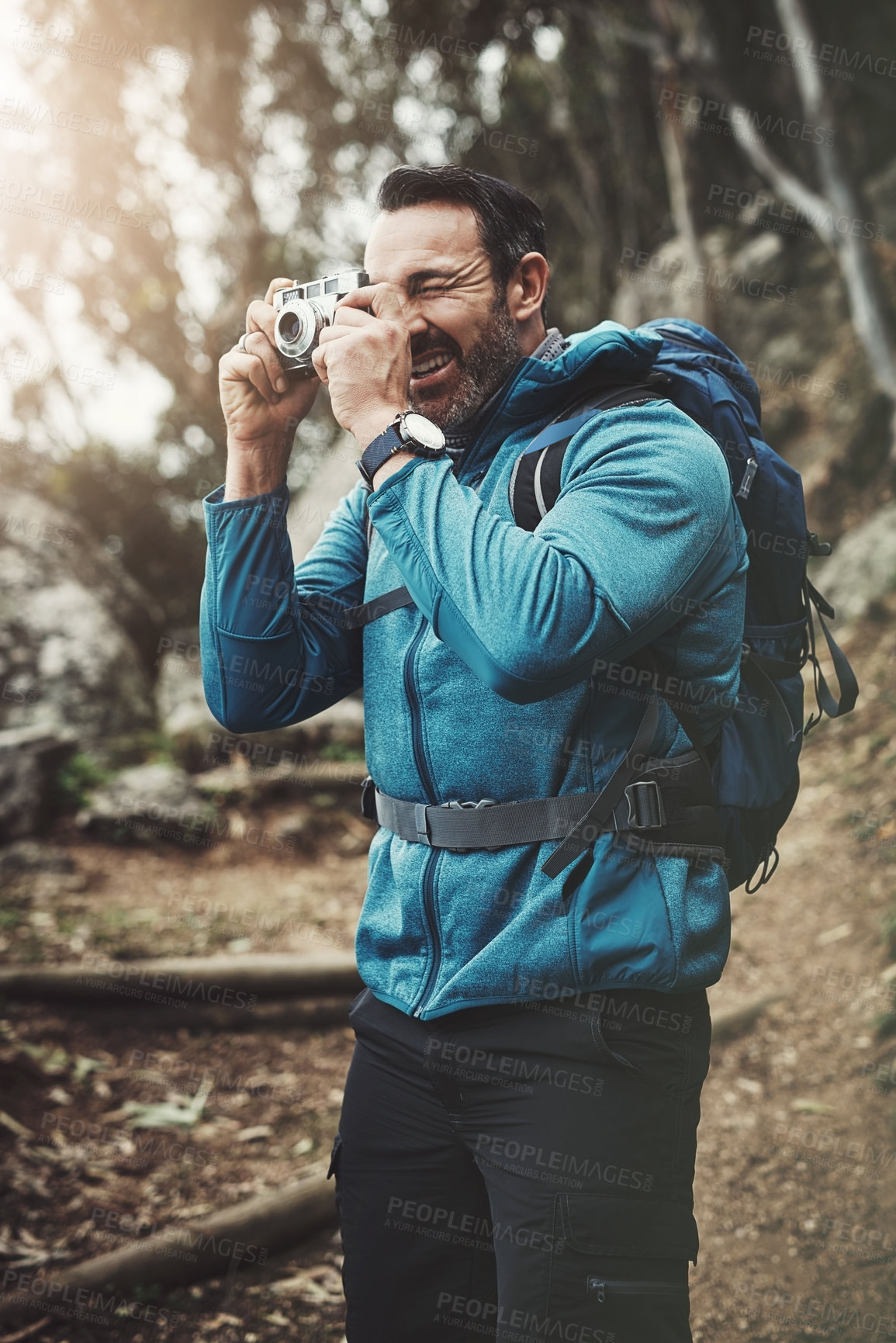 Buy stock photo Forest, camera and man in woods for photography, travel and hiking, journey or memory. Jungle, backpack and mature wildlife photographer with digital lens for adventure, explore or nature discovery