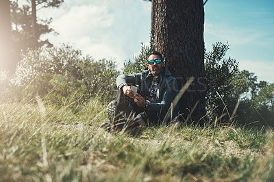 Buy stock photo Tree, nature and man on ground, smartphone and sunglasses with sunshine, grass and environment. Explore, person and guy with clouds, adventure and journey with vacation, cellphone and getaway trip
