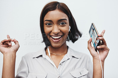 Buy stock photo Studio portrait of a young creative businesswoman listening to music on her cellphone against a grey background