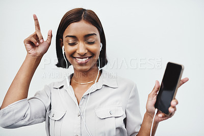 Buy stock photo Studio shot of a young creative businesswoman listening to music on her cellphone against a grey background